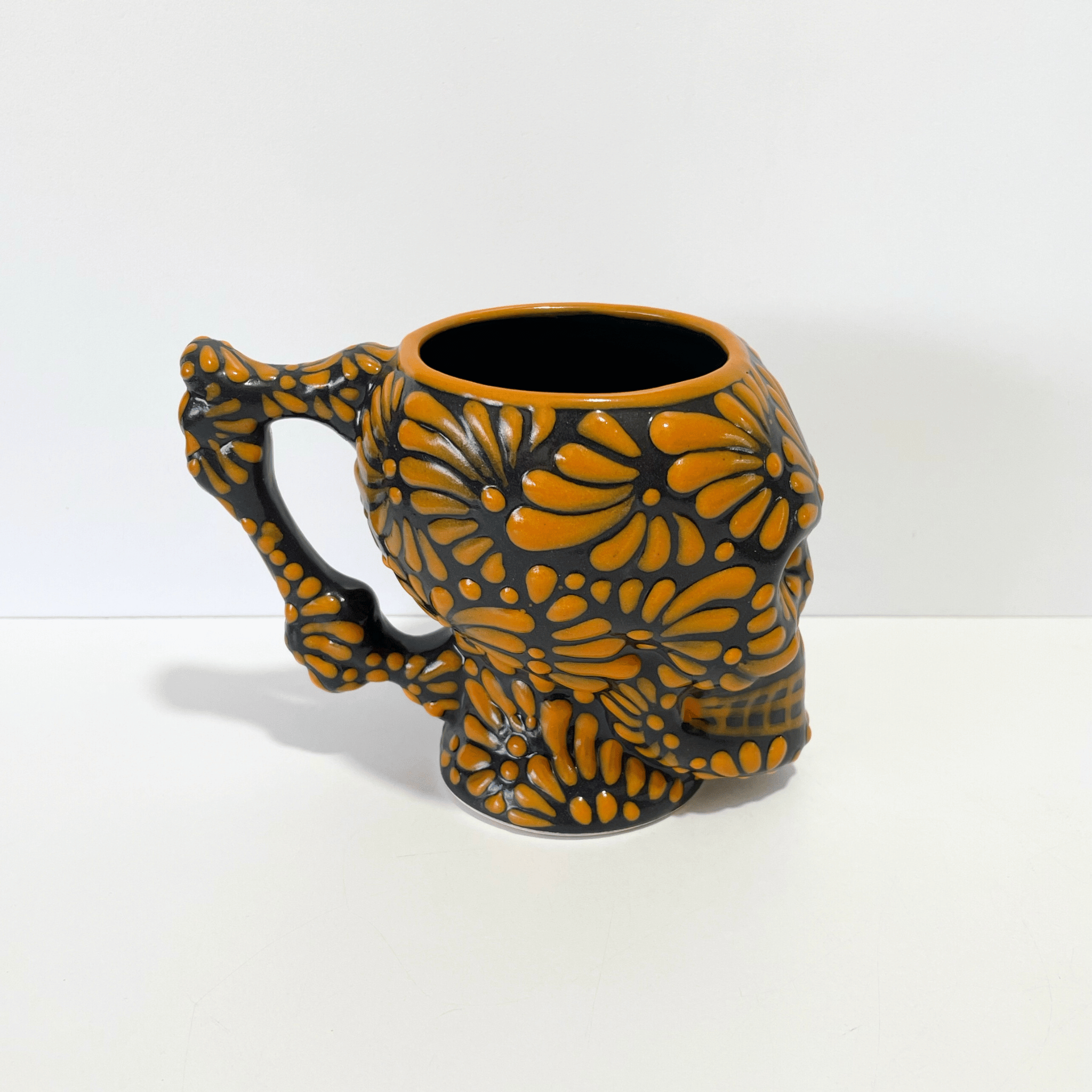 TAZA FORMA DE CRANEO FONDO NEGRO MIK NARANJA